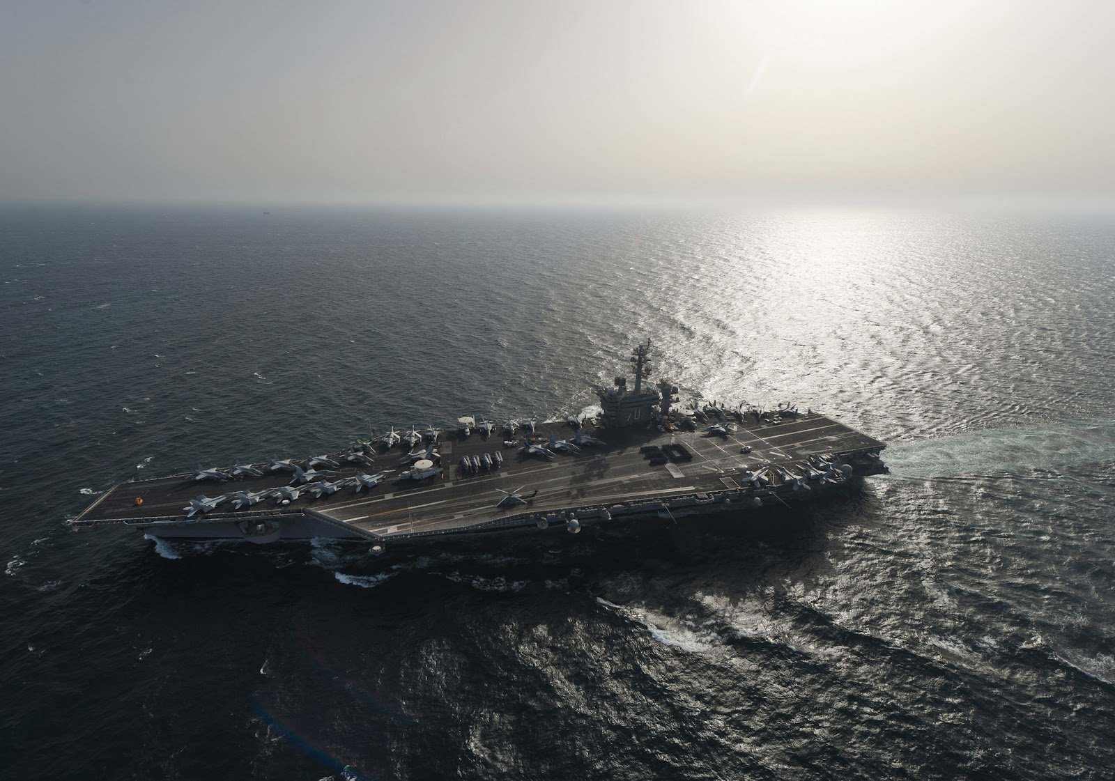 HD desktop wallpaper featuring the USS Carl Vinson (CVN-70) aircraft carrier sailing on open water, showcasing its military power and naval design.