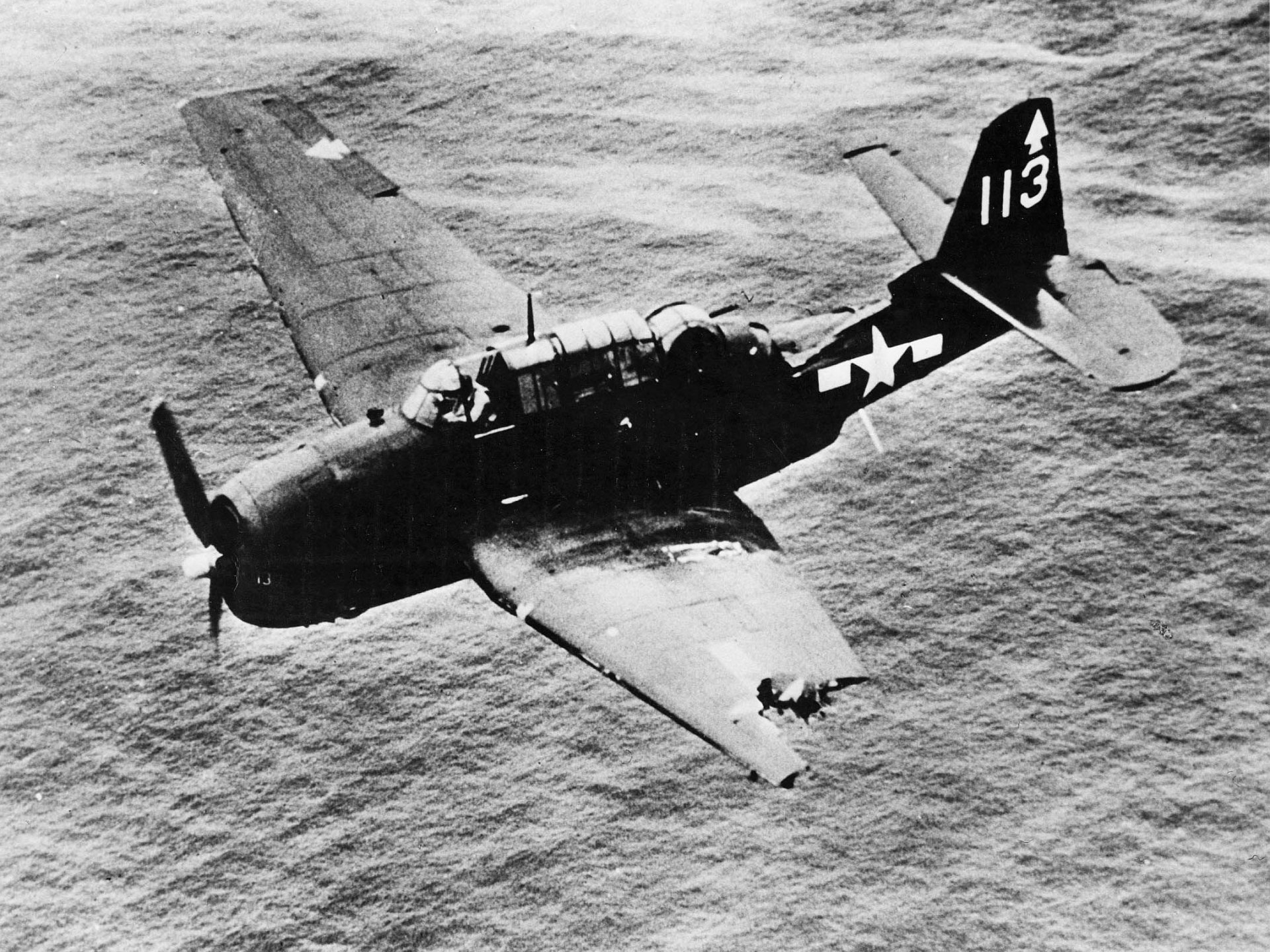 Grumman TBF Avenger torpedo bomber in flight over the ocean, black-and-white military photo presented as an HD PC desktop wallpaper/background.
