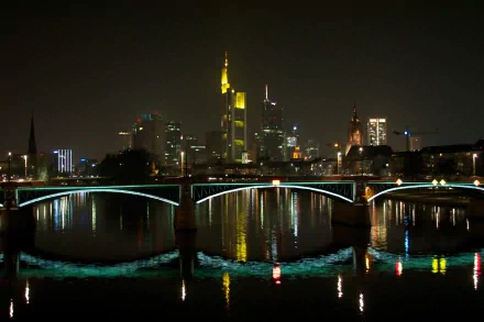 Frankfurt night skyline with illuminated skyscrapers and an arched bridge reflecting on the river — man-made 2K Quad HD PC desktop wallpaper/background.