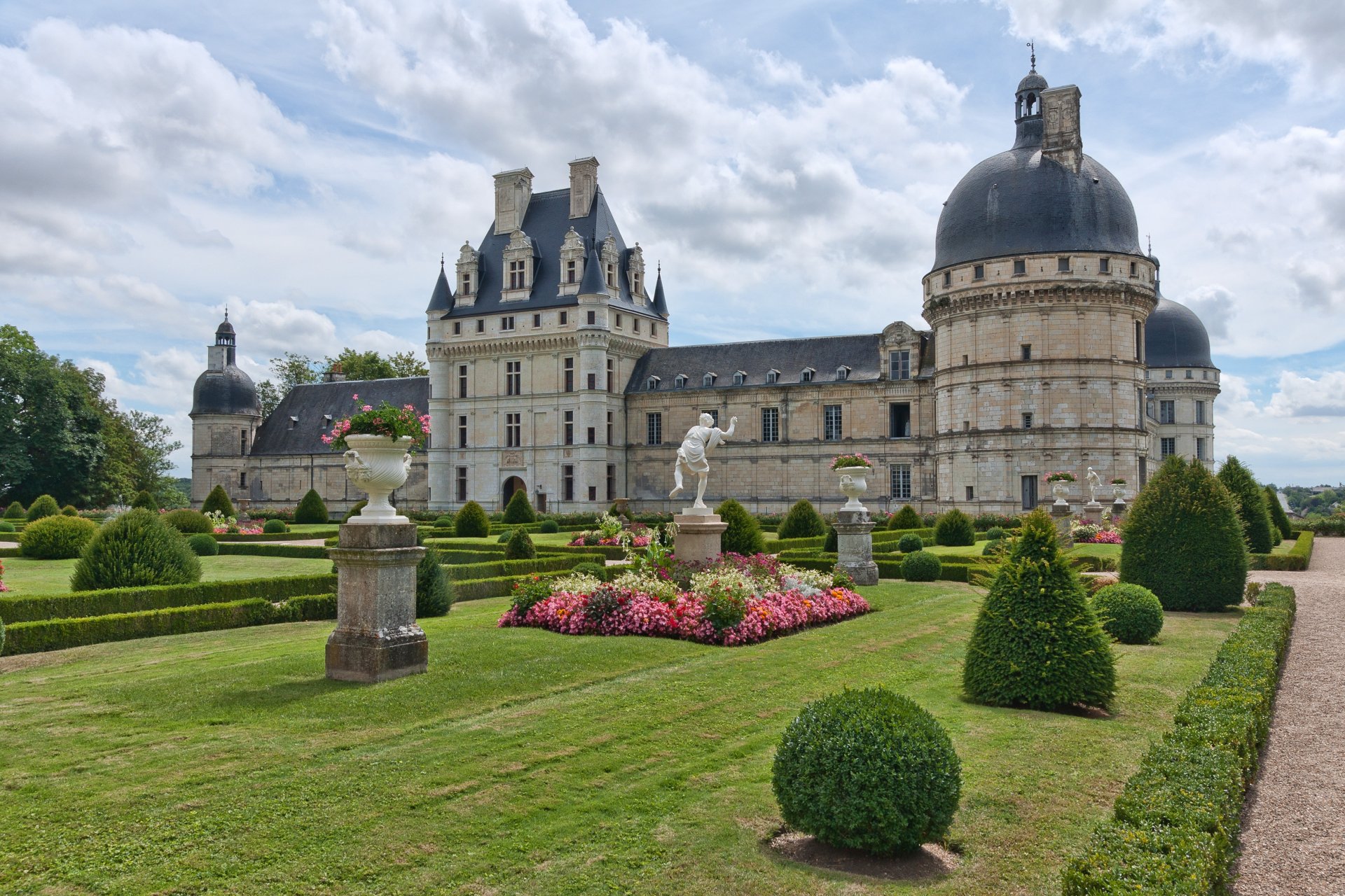 A 4K Ultra HD image of the Château de Valençay, showcasing its historic architecture and manicured gardens under a partly cloudy sky.