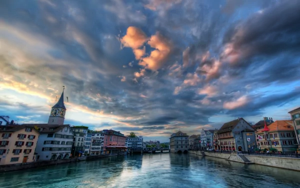 A stunning view of Zurich, Switzerland, featuring colorful buildings along the river, dramatic clouds, and a picturesque urban landscape in vibrant HDR.