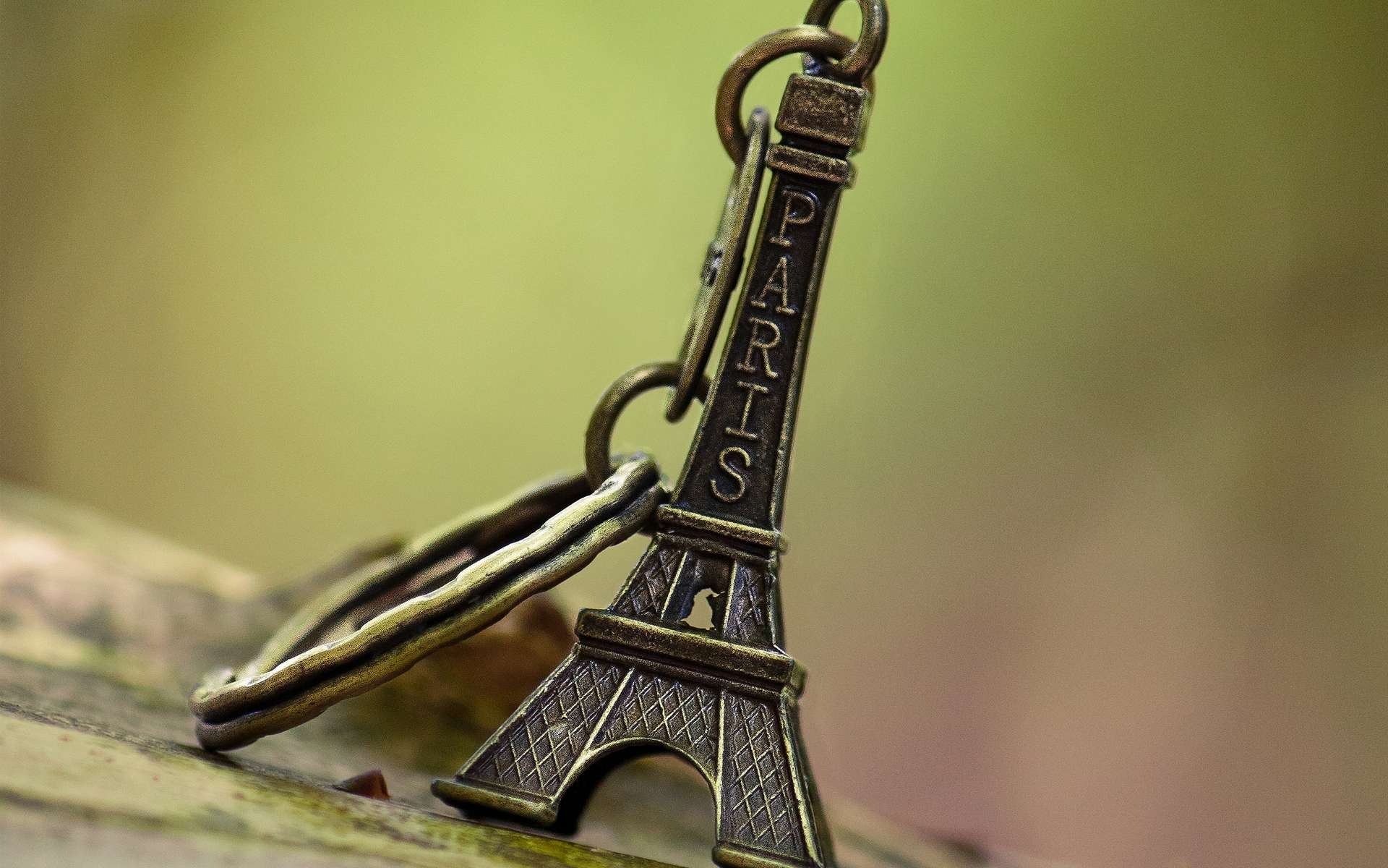 Close-up of a man-made Eiffel Tower keychain in soft focus, captured in HD detail as a desktop wallpaper and background.