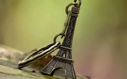 Close-up of a man-made Eiffel Tower keychain in soft focus, captured in HD detail as a desktop wallpaper and background.