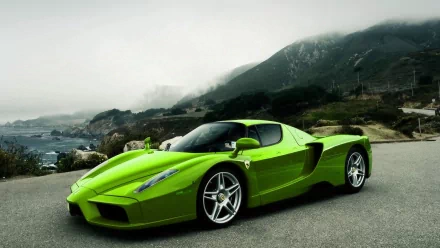 A striking green Ferrari Enzo parked along a scenic coastal road, set against a dramatic landscape, makes for an impressive HD desktop wallpaper and background.