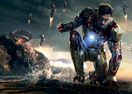 HD desktop wallpaper featuring Iron Man from the movie Iron Man 3, kneeling with an intense expression, glowing arc reactor, and multiple Iron Man suits in the background amid a dramatic, explosive scene.