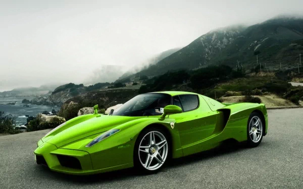 A striking green Ferrari Enzo parked along a scenic coastal road, set against a dramatic landscape, makes for an impressive HD desktop wallpaper and background.