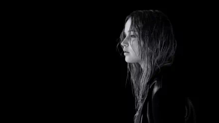 A striking black and white HD wallpaper featuring celebrity Jennifer Lawrence, captured in a contemplative profile against a dark backdrop.