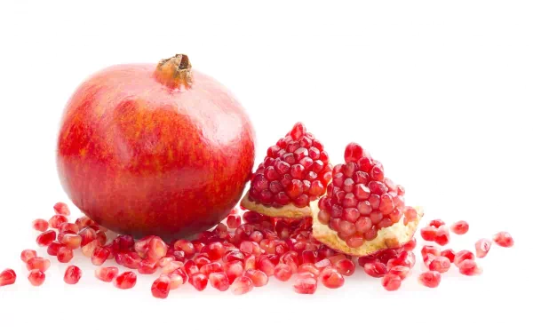 HD PC desktop wallpaper featuring a vibrant whole pomegranate and its scattered seeds on a clean white background.