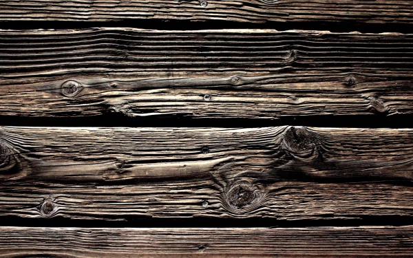 Artistic HD wallpaper featuring rich textures of dark, weathered wood planks, showcasing unique knots and grain patterns for a rustic and warm background.