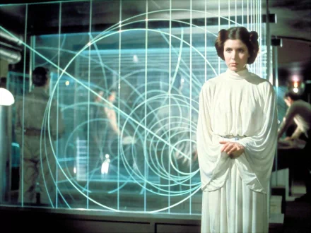 Carrie Fisher as Princess Leia Organa in a scene from *Star Wars Episode IV: A New Hope*, featuring her iconic hairstyle and attire against a backdrop of futuristic graphics.