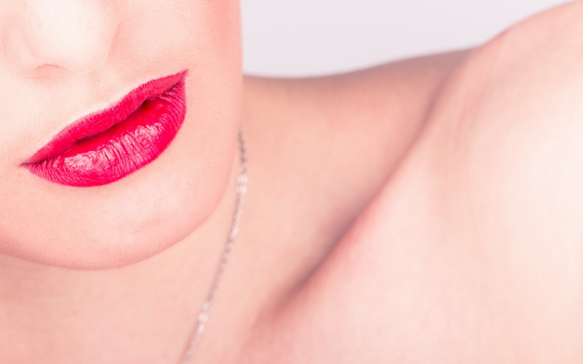 Close-up of a woman's lips with vibrant red lipstick, set against a soft background. This HD image serves as a striking desktop wallpaper and background.