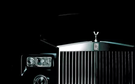 HD desktop wallpaper featuring the front grille and iconic mascot of a Rolls-Royce Phantom against a black background.