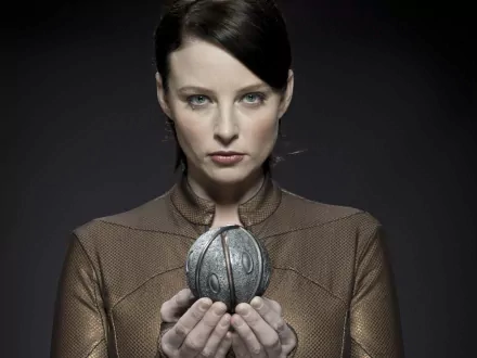 Stoic woman in a futuristic uniform holding a metal orb, promotional image for TV show Continuum — 5K Ultra HD PC desktop wallpaper/background.