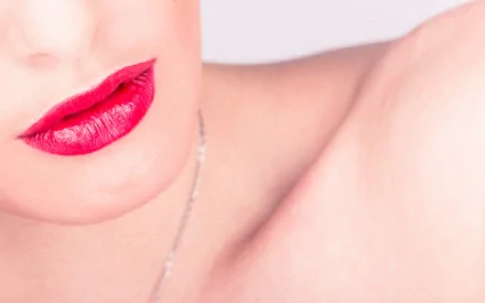 Close-up of a woman's lips with vibrant red lipstick, set against a soft background. This HD image serves as a striking desktop wallpaper and background.