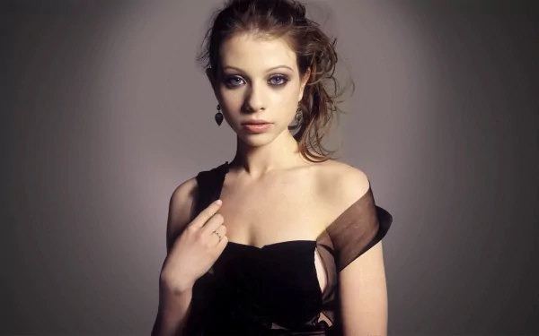 A striking HD wallpaper featuring celebrity Michelle Trachtenberg, showcasing her elegant pose and captivating expression in a stylish black dress.