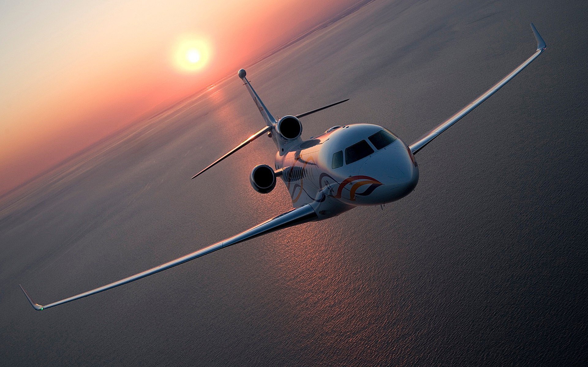Dassault Falcon 7X vehicle — business jet gliding over a sunlit ocean at sunset; HD PC desktop wallpaper/background.