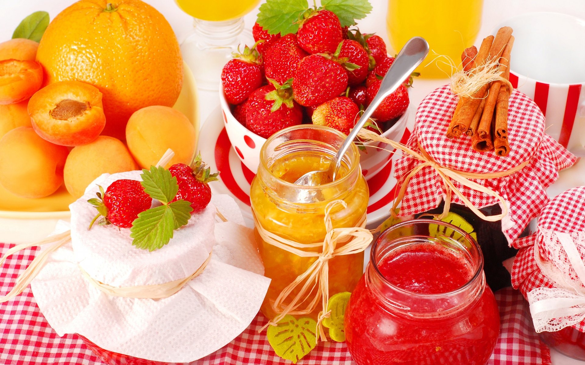 HD PC desktop wallpaper featuring a vibrant arrangement of fresh fruits, jars of fruit preserves, and cinnamon sticks on a red checkered cloth.