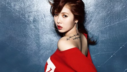 A striking HD wallpaper featuring Kim Hyun-a in a bold red outfit, showcasing her signature style and captivating expression against a textured blue background.