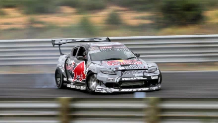 HD PC desktop wallpaper: race-prepped Mazda RX-8 with Red Bull graphics hugging a racetrack, motion-blurred background and detailed aero mods.