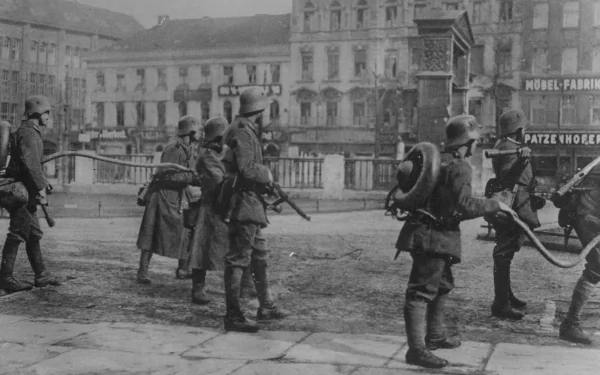 World War II military soldiers patrol a city street, captured in a detailed 4K Ultra HD PC desktop wallpaper and background.
