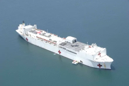 Aerial view of the USNS Comfort (T-AH-20), a military hospital ship, sailing calmly on open water in this HD desktop wallpaper.