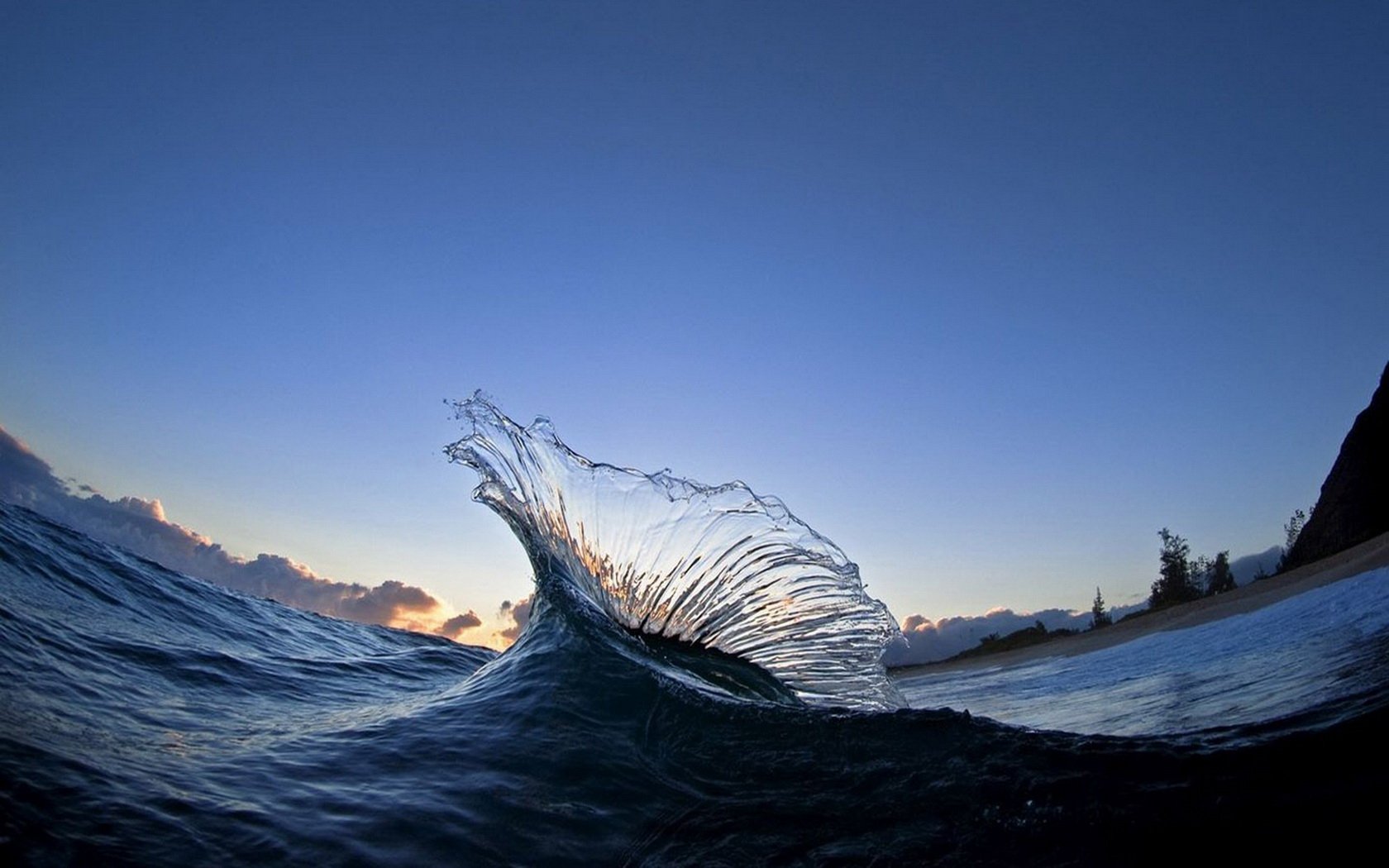HD PC desktop wallpaper: nature scene of a glassy ocean wave cresting against a clear twilight sky.