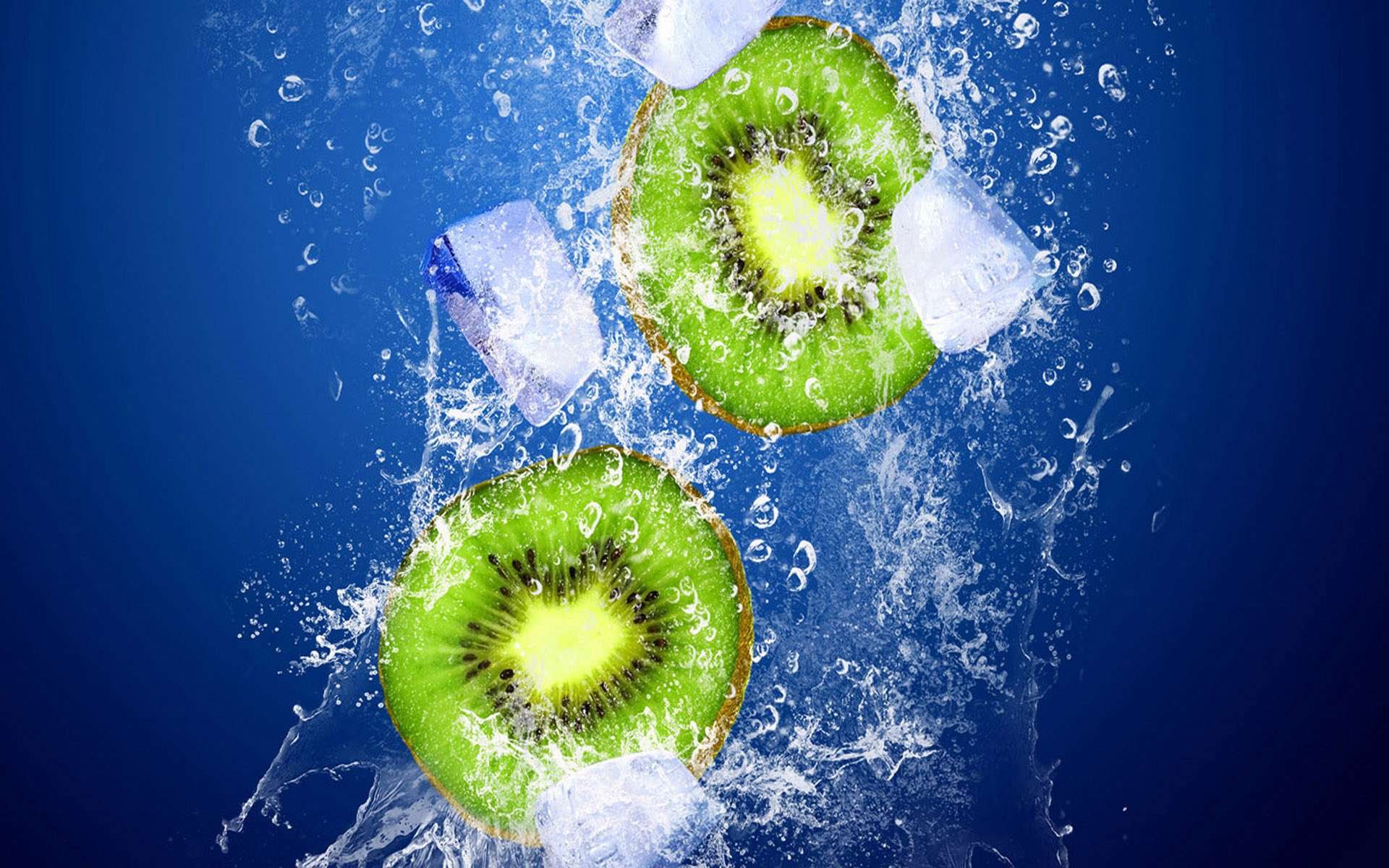 Two vibrant kiwi slices with ice cubes splash underwater against a blue background, captured in HD for a fresh PC desktop wallpaper.