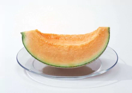 HD PC desktop wallpaper featuring a close-up of a fresh cantaloupe melon slice on a clear plate against a white background.