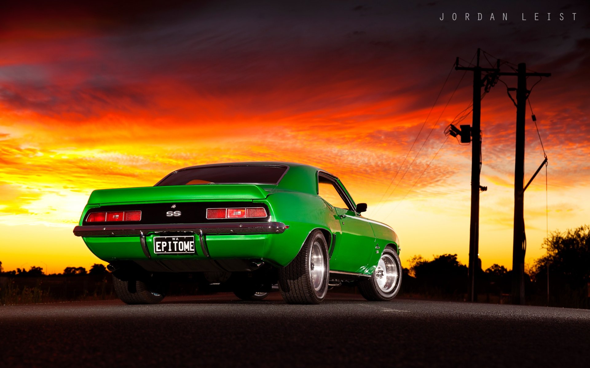 HD PC desktop wallpaper featuring a vibrant green Chevrolet Camaro SS against a dramatic sunset sky and silhouetted power lines.