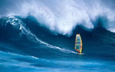 HD desktop wallpaper capturing a vibrant windsurfer navigating a massive ocean wave, showcasing dynamic motion and the thrill of watersports.