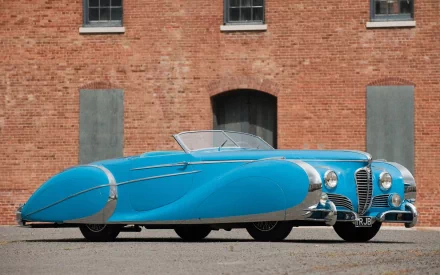 A blue Delahaye 175 S Saoutchik Roadster parked in front of a brick building, featured as a high-definition PC desktop wallpaper and background.