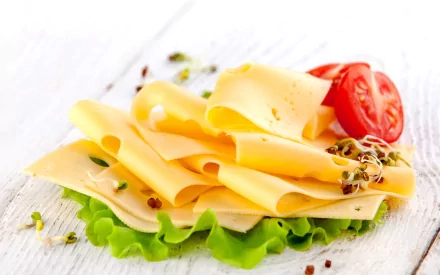 HD PC desktop wallpaper featuring thin slices of cheese with fresh lettuce, cherry tomato halves, and sprouted seeds on a white wooden surface.
