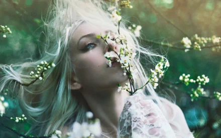 HD desktop wallpaper featuring a woman with flowing hair surrounded by blossoming branches, evoking a serene and contemplative mood.