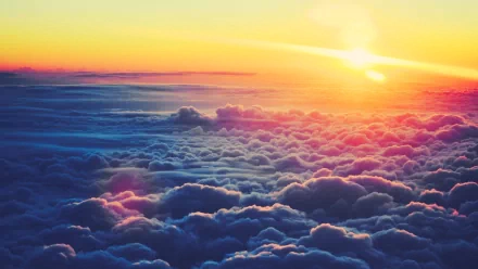 A breathtaking HD PC desktop wallpaper featuring vibrant clouds illuminated by a stunning sunrise, blending shades of orange and purple in a serene natural landscape.