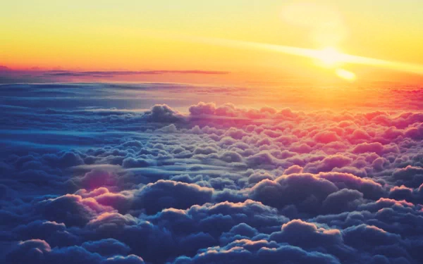 A breathtaking HD PC desktop wallpaper featuring vibrant clouds illuminated by a stunning sunrise, blending shades of orange and purple in a serene natural landscape.
