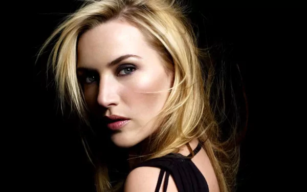 A captivating HD desktop wallpaper featuring actress Kate Winslet with a striking pose and flowing hair against a dark background, exuding elegance and intensity.