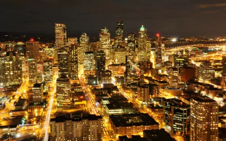 A vibrant nighttime cityscape of Seattle, showcasing illuminated skyscrapers and streets in a high-definition, man-made urban setting.