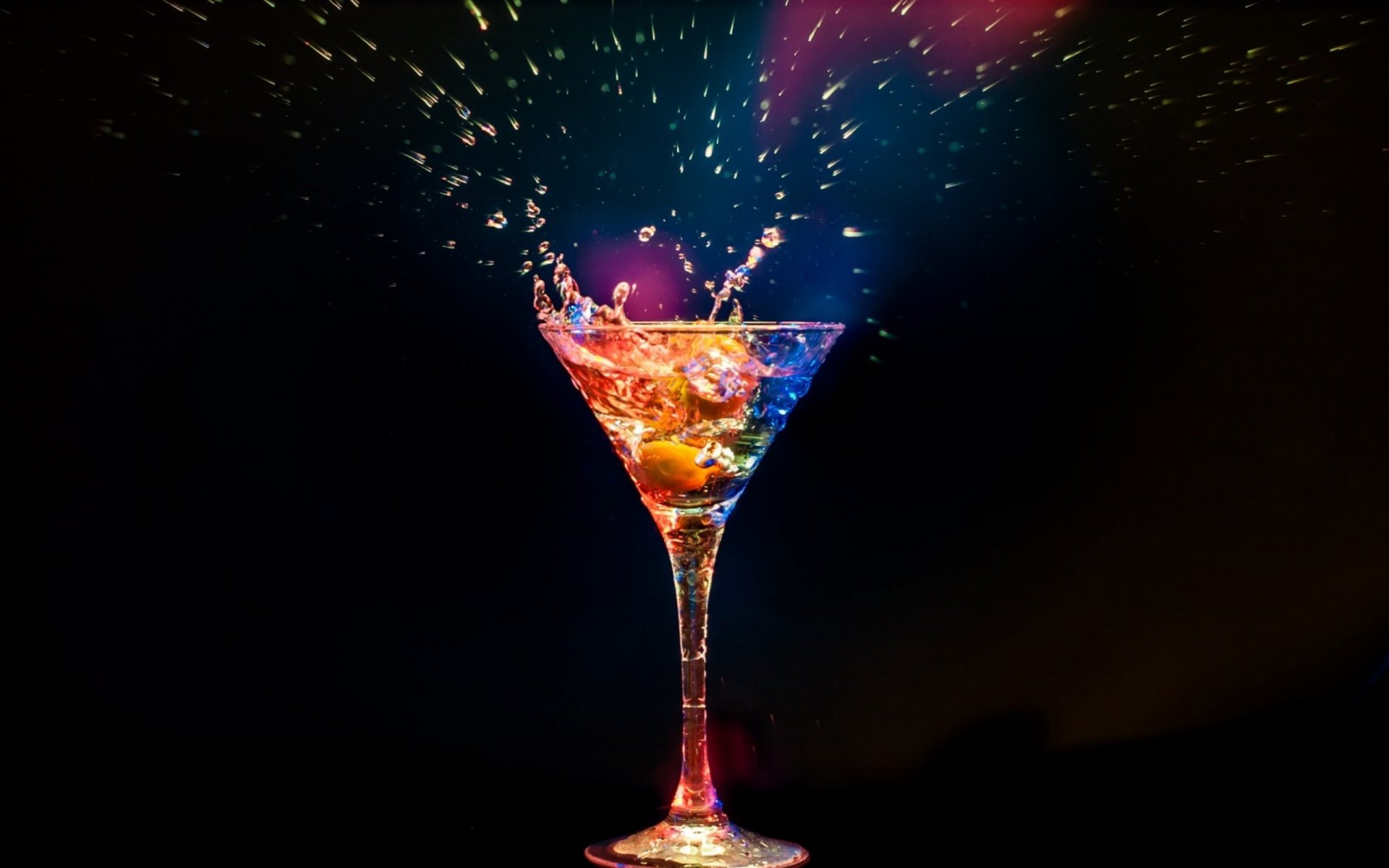 HD desktop wallpaper of a colorful cocktail splashing with vibrant liquid and fruit against a dark background, highlighting dynamic motion and vivid colors.