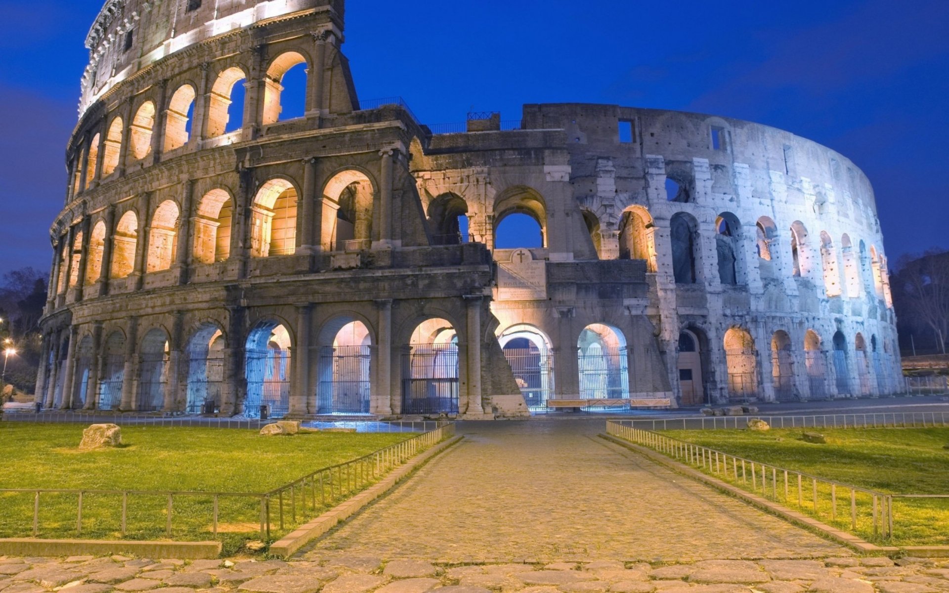 HD PC desktop wallpaper featuring the illuminated man-made Colosseum at dusk against a deep blue sky.