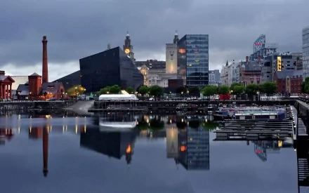 HD desktop wallpaper showcasing Liverpool’s man-made waterfront with modern buildings and calm water reflecting the cityscape at dusk.