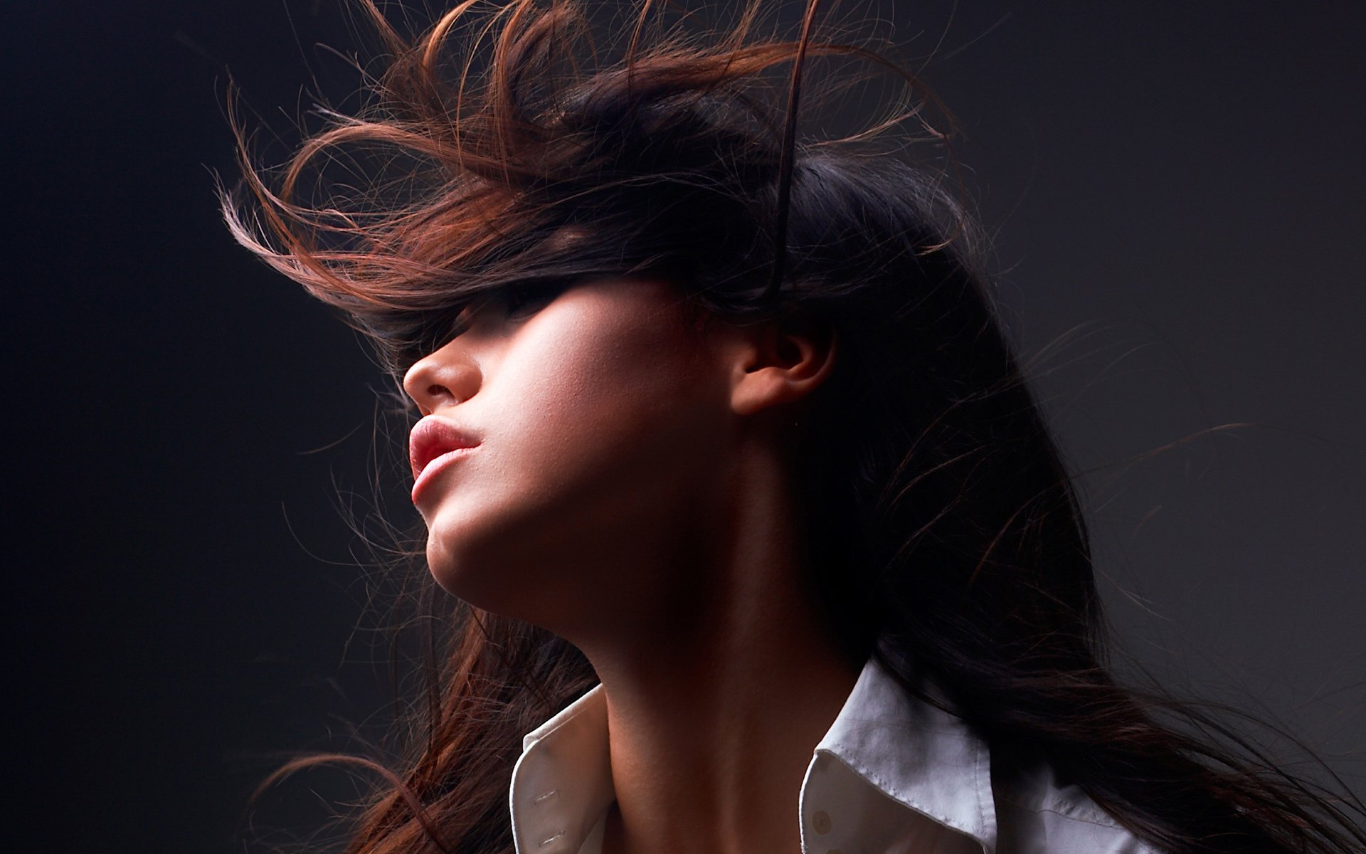 HD PC desktop wallpaper background: woman with flowing hair swept across her face, head tilted back against a dark backdrop.