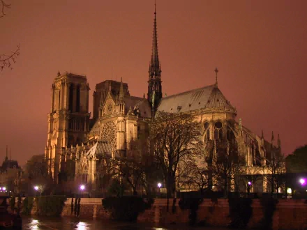 HD desktop wallpaper of Notre-Dame de Paris at dusk, showcasing the iconic religious architecture illuminated against a warm, reddish evening sky.