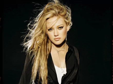 HD desktop wallpaper featuring celebrity Hilary Duff with long blonde hair and a confident expression against a dark background.