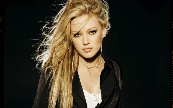 HD desktop wallpaper featuring celebrity Hilary Duff with long blonde hair and a confident expression against a dark background.