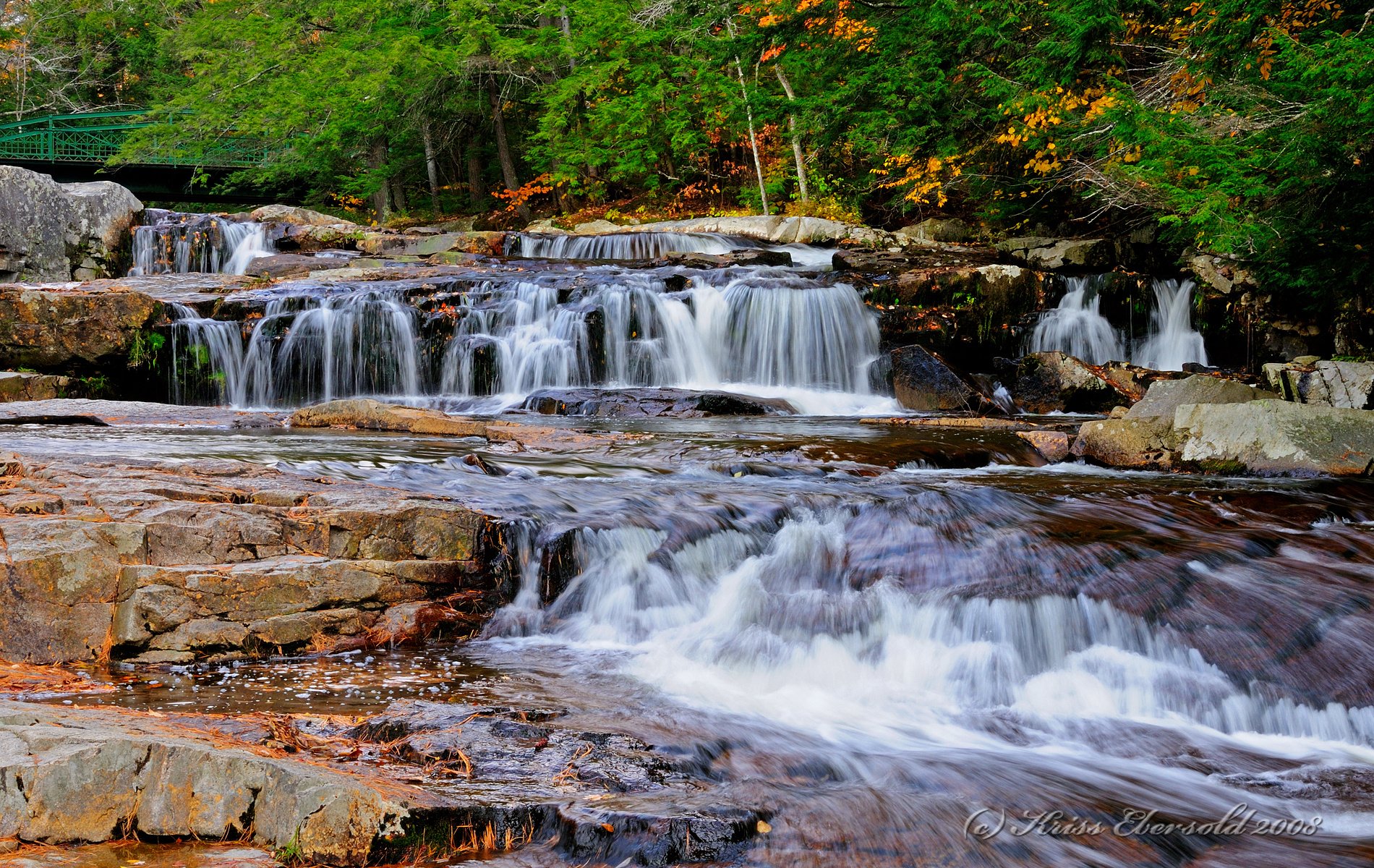 Nature stream HD PC desktop wallpaper and background: crisp forest stream cascading over rocky ledges, framed by lush green trees and warm autumn foliage.