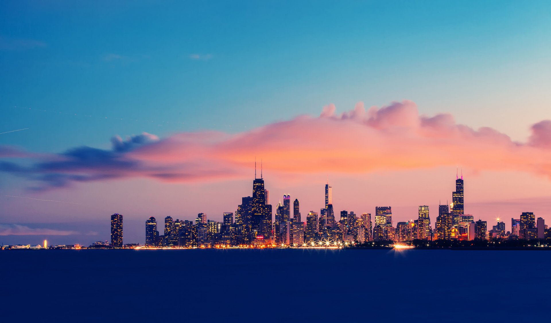 HD desktop wallpaper showcasing the man-made Chicago skyline at dusk, with vibrant pink and blue hues in the sky above the illuminated cityscape.