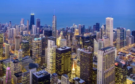 A stunning HD wallpaper showcasing the vibrant skyline of Chicago at dusk, highlighting the city's iconic architecture and shimmering lights along Lake Michigan.