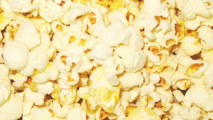 Close-up HD desktop wallpaper of freshly popped popcorn with fluffy white kernels and golden accents, highlighting the texture and color of the snack.