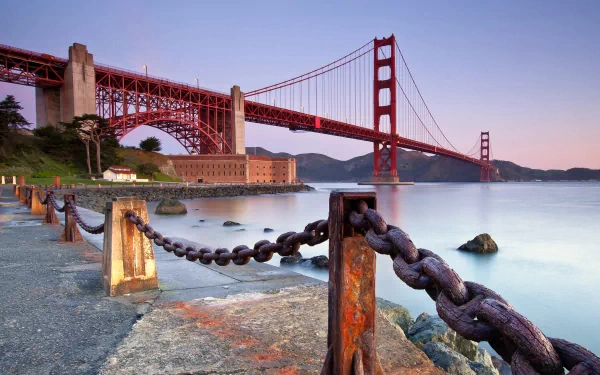 HD desktop wallpaper featuring the iconic man-made Golden Gate Bridge at dusk with a foreground of large chains along the waterfront.