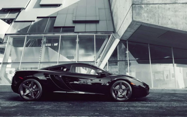 Sleek black McLaren MP4-12C supercar parked in front of a modern architectural building, captured as an HD PC desktop wallpaper and background.